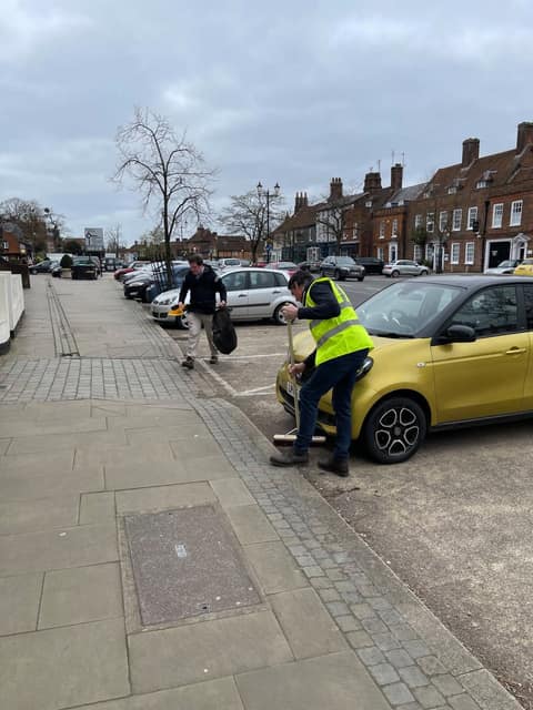 Volunteers sweeping and picking litter on an Old Town pavement