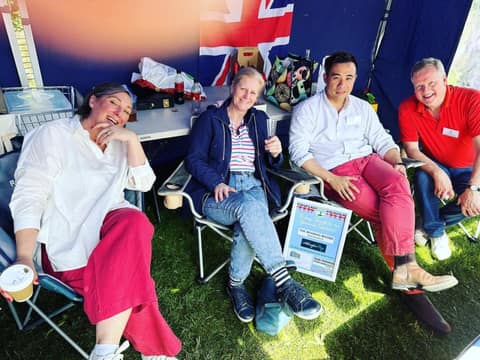 Jackson relaxing in a deckchair with residents in a gazebo at the coronation picnic